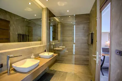 a bathroom with two sinks and two mirrors at Ocean Rock Kalim in Patong Beach