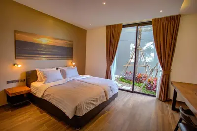a bedroom with a large bed and a large window at Ocean Rock Kalim in Patong Beach