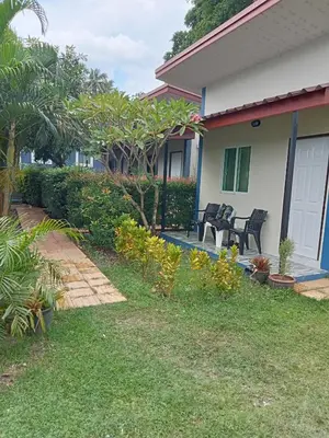 a house with chairs and plants in the yard at Airee Mini House in Bang Tao Beach