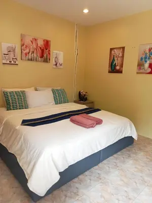 a bedroom with a large bed in a room at Airee Mini House in Bang Tao Beach