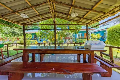 a picnic table with a pergola and a bench at RAT VILLA in Ban Pa Khlok