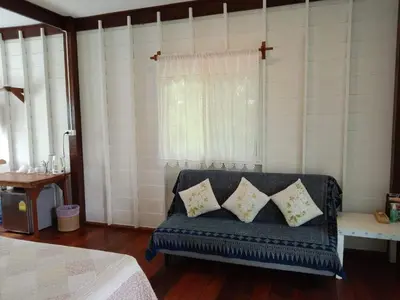 a blue couch with pillows in a room with a window at The Best Bungalow in Ban Bang Chak