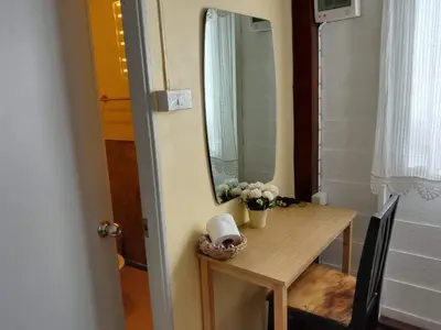 a small table with a mirror and flowers on it at The Best Bungalow in Ban Bang Chak