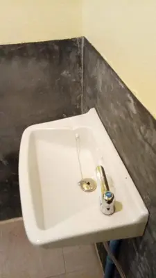 a white sink in a bathroom with a metal drain at The Best Bungalow in Ban Bang Chak