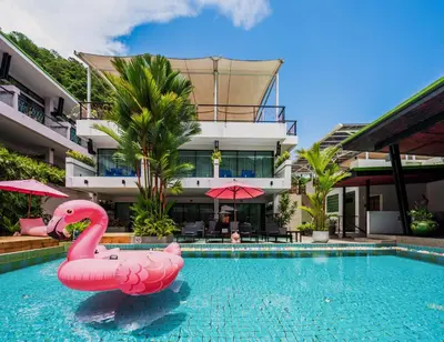 a pink flamingo in a swimming pool in front of a building at CC's Hideaway Kata - SHA Plus in Kata Beach