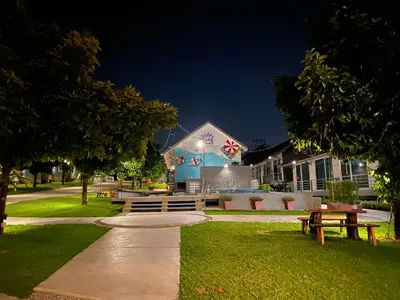 a park with benches and a building at night at Be Leaf Resort SHA in Thalang