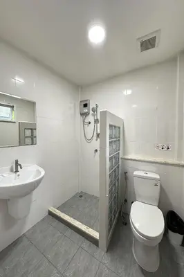 a bathroom with a shower and a toilet and a sink at Be Leaf Resort SHA in Thalang