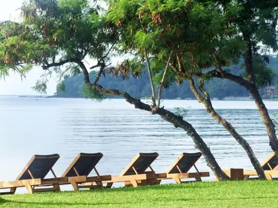 a row of lounge chairs sitting next to the water at The Vijitt Resort Phuket - SHA Extra Plus in Rawai Beach
