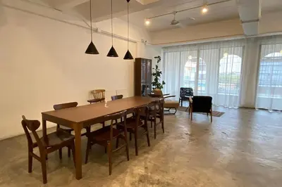 a dining room with a wooden table and chairs at Our Nomad Boutique Hostel in Phuket Town