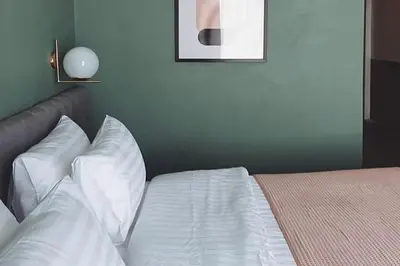a bedroom with a bed with white sheets and pillows at Our Nomad Boutique Hostel in Phuket Town