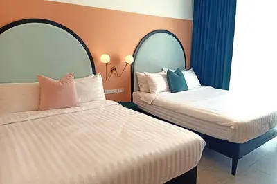 a hotel room with two beds and two mirrors at Our Nomad Boutique Hostel in Phuket Town