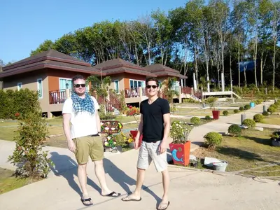 two men are standing in front of a house at Sunrise Beach Kohyao Resort in Ko Yao Yai