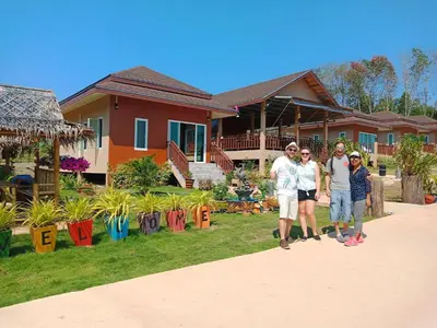 a group of people standing in front of a house at Sunrise Beach Kohyao Resort in Ko Yao Yai