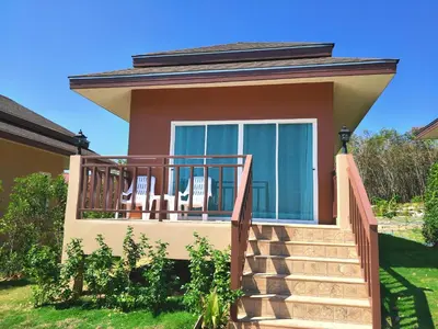 a house with a balcony with two chairs on it at Sunrise Beach Kohyao Resort in Ko Yao Yai