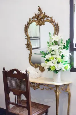 a vase of flowers on a table with a mirror at Sound Gallery House - SHA Plus in Phuket Town
