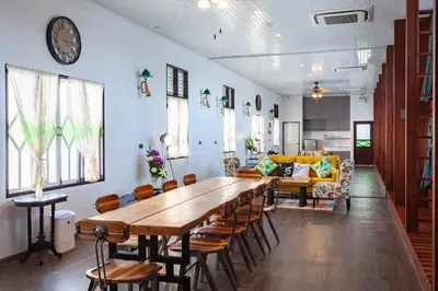 a dining room with a large wooden table and chairs at Sound Gallery House - SHA Plus in Phuket Town