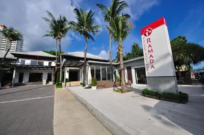 a sign in front of a building with palm trees at Ramada by Wyndham Phuket Southsea in Karon Beach