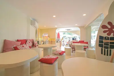 a restaurant with tables and chairs and a surfboard at Ramada by Wyndham Phuket Southsea in Karon Beach
