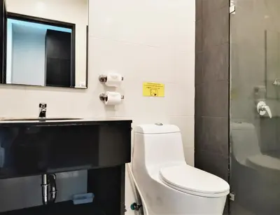 a bathroom with a toilet and a sink and a mirror at Naiyang Beach Hotel SHA Plus in Nai Yang Beach