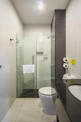 a bathroom with a toilet and a glass shower at Naiyang Beach Hotel SHA Plus in Nai Yang Beach