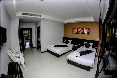 a hotel room with two beds and a tv at Naiyang Beach Hotel SHA Plus in Nai Yang Beach