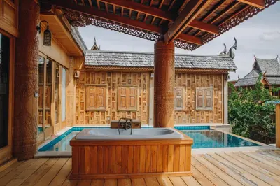 a bath tub on a deck next to a pool at Santhiya Phuket Natai Resort & Spa in Natai Beach