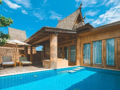 a villa with a swimming pool and a house at Santhiya Phuket Natai Resort & Spa in Natai Beach