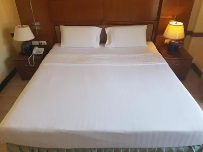a large white bed with two lamps and a phone at Phi Phi Hotel in Phi Phi Don