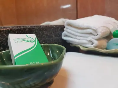 a green bowl on a table with a pile of towels at Phi Phi Hotel in Phi Phi Don