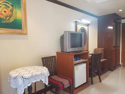 a living room with a tv and a table and chairs at Phi Phi Hotel in Phi Phi Don
