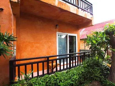 an orange building with a balcony and a window at P.P. Casita - Adult Only in Phi Phi Don