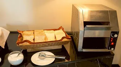 a kitchen with a counter with a basket of bread at Beehive Boutique Hotel Phuket in Phuket Town