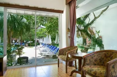 a room with a table and chairs and a sliding glass door at Garden Home Kata in Kata Beach