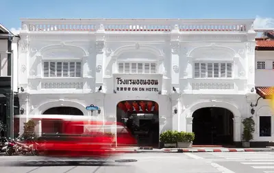 a white building with a sign on the front of it at The Memory at On On Hotel in Phuket Town