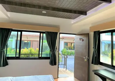 a bedroom with a bed and a door with windows at Thalang resort in Thalang