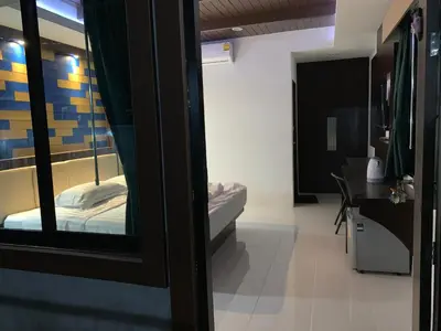 a room with a bedroom with a bed and a mirror at Thalang resort in Thalang