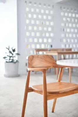 a wooden chair in a room with a table at At Kamala Hotel in Kamala Beach