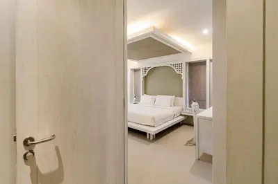 a white bedroom with a bed and a bathroom at Villa Pimmada in Ao Nang Beach