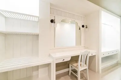 a white bathroom with a mirror and a chair at Villa Pimmada in Ao Nang Beach