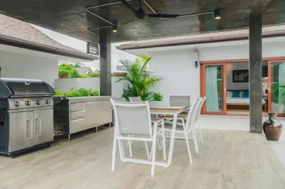 a kitchen with a table and chairs and a stove at Bangtao Boutique Villa in Bang Tao Beach