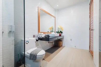 a bathroom with a toilet and a sink and a mirror at Bangtao Boutique Villa in Bang Tao Beach