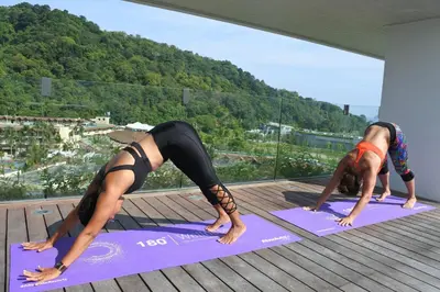 three people doing a yoga pose on a balcony at Absolute Twin Sands Resort & Spa - SHA Extra Plus in Patong Beach