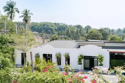 a white house with flowers in front of it at The Loft Panwa Resort in Panwa Beach