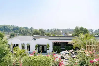 a white house with flowers in front of it at The Loft Panwa Resort in Panwa Beach