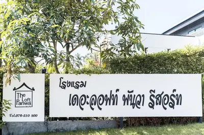 a sign in front of a building with trees at The Loft Panwa Resort in Panwa Beach