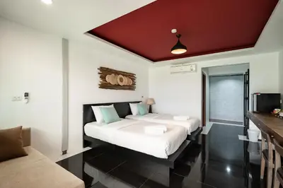a bedroom with two beds and a couch at The Loft Panwa Resort in Panwa Beach