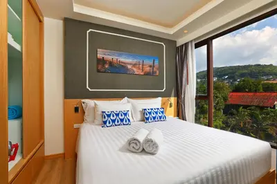 a bedroom with a white bed with a large window at The Aristo Beach by Holy Cow, studio, construction view in Surin Beach
