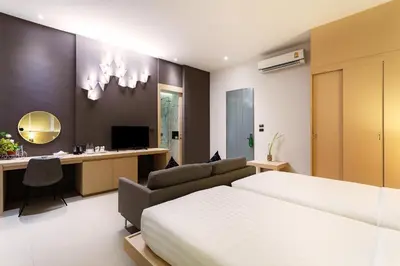 a bedroom with a bed and a desk at The Palmery Resort in Kata Beach