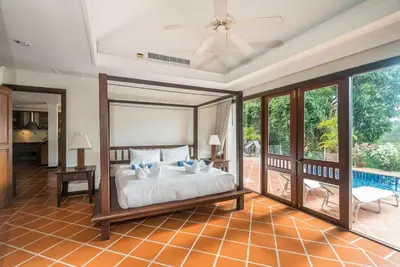 a bedroom with a bed and a swimming pool at Pool villa at Nakatani Village by Lofty in Kamala Beach