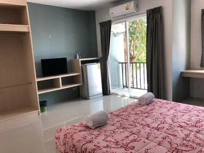 a bedroom with a bed and a television and a window at Khao Oat airport in Nai Yang Beach